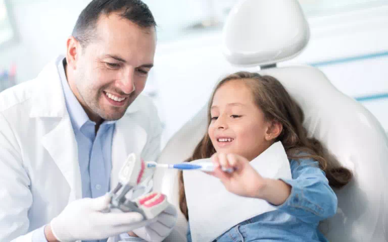 dentysta uczący dziecko myć zęby
